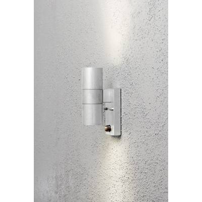 Cylindryczna lampa zewnętrzna z metalu na szarej ścianie, emitująca światło w górę i w dół. Eleganckie oświetlenie do nowoczesnej przestrzeni zewnętrznej.