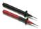 Dwie przewody pomiarowe z czarnymi i czerwonymi uchwytami, każdy zakończony metalowym grotem. Służą do pomiarów elektrycznych.