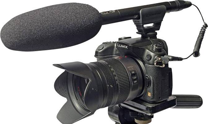 Cyfrowy aparat fotograficzny z podłączonym mikrofonem zewnętrznym, zamontowany na statywie, gotowy do profesjonalnego nagrywania wideo.