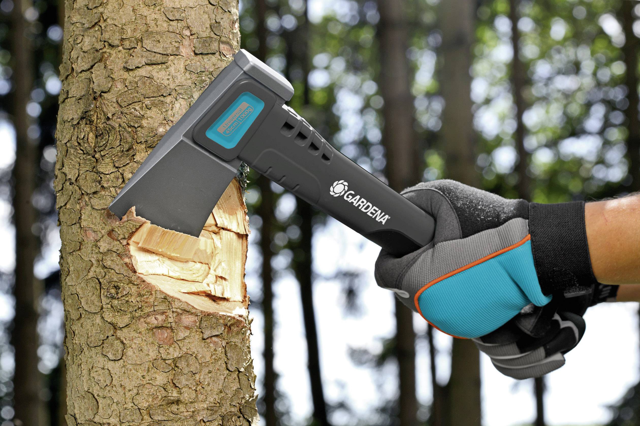 Siekiera jest trzymana przez osobę w rękawicach ogrodowych i jest wbita w pień drzewa, aby je ściąć.