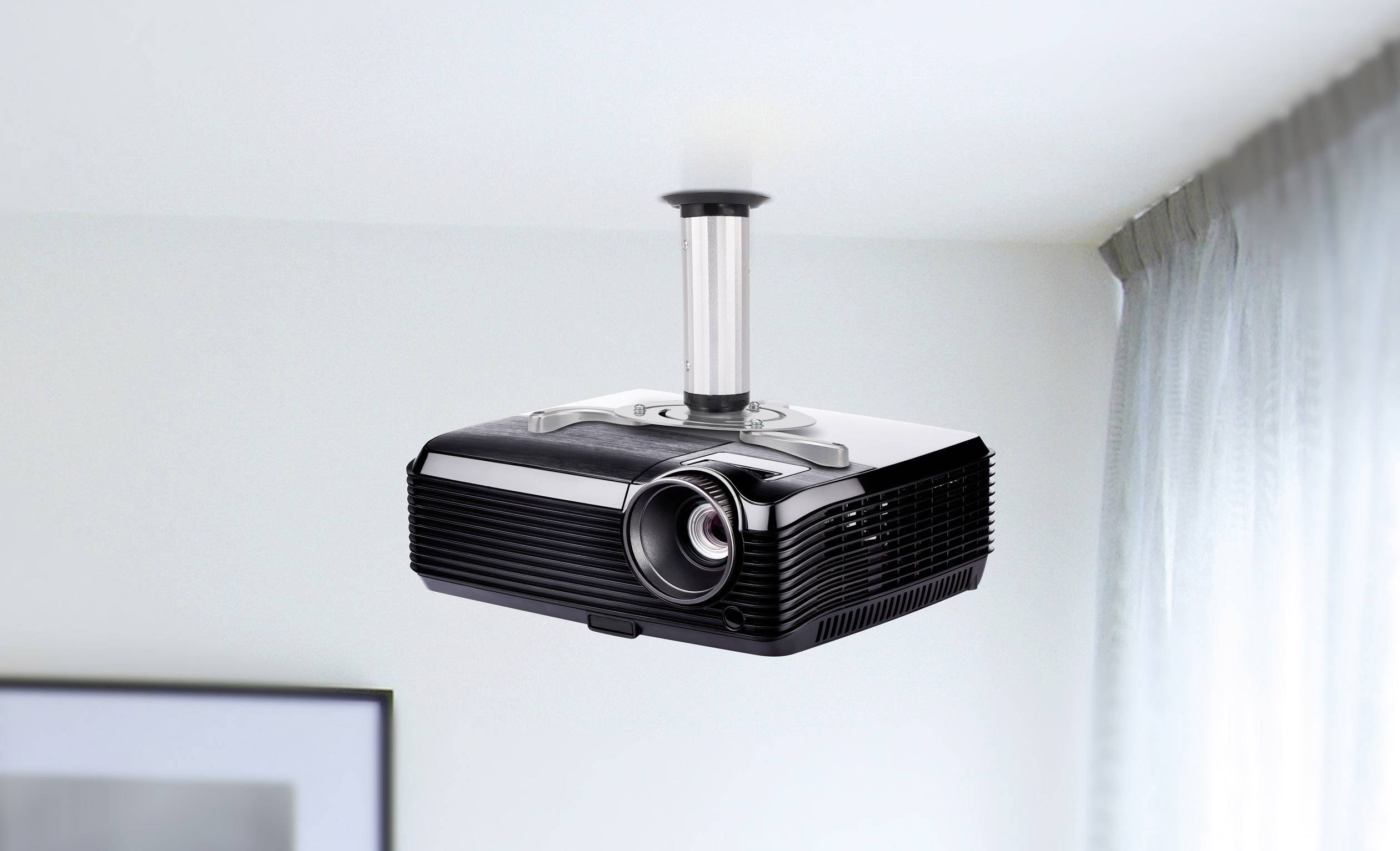 Projektor zamontowany na suficie, gotowy do wyświetlania. Prawa krawędź pomieszczenia z fragmentem zasłony jest widoczna.