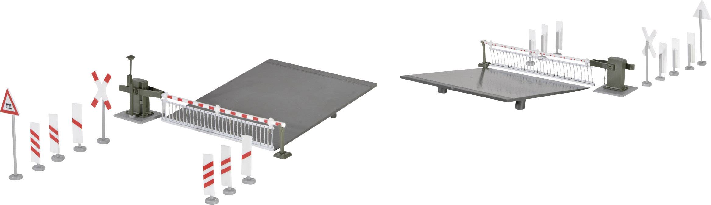 Dwa modele zapór kolejowych z sygnalizacją i znakami drogowymi na szarych platformach. Oba służą do symulacji przejazdu kolejowego.