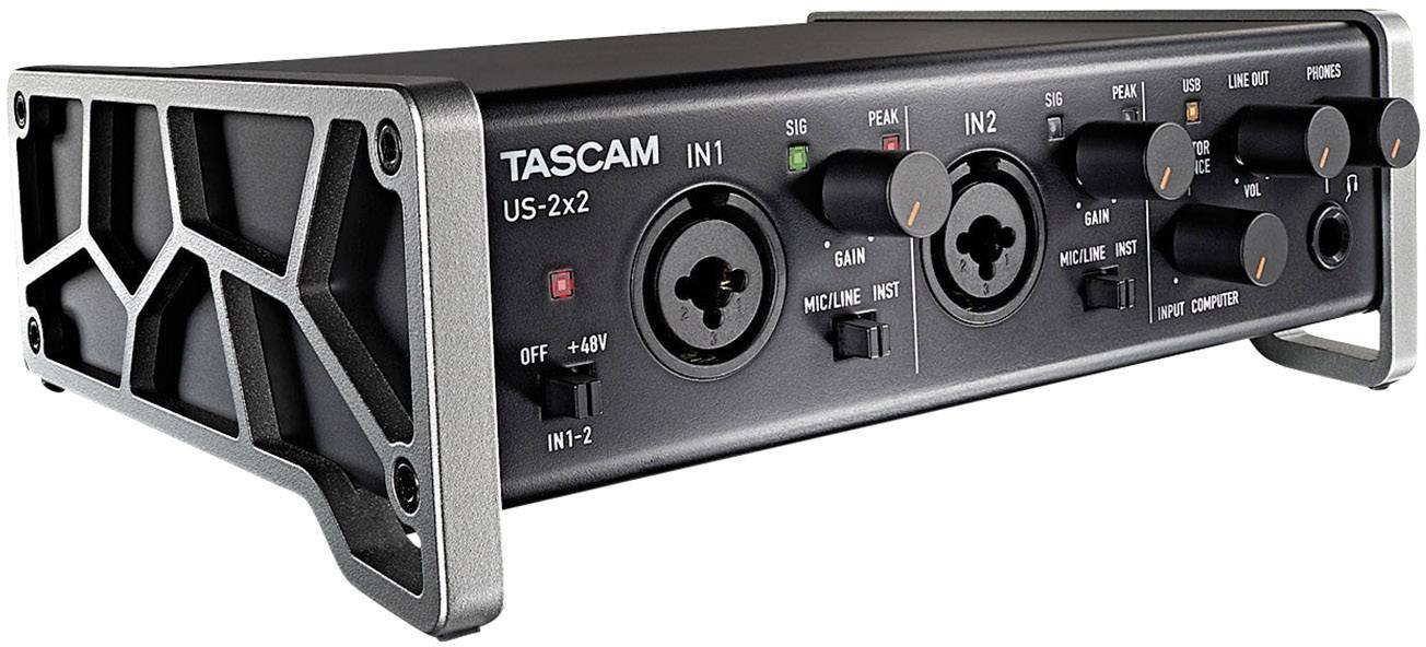 Interfejs audio z dwoma wejściami XLR, regulatorem wzmocnienia, wskaźnikami sygnału i przesterowania, oznaczony jako 'Tascam US-2x2', przeznaczony do urządzeń nagrywających.