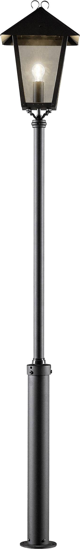 Czarna latarnia o klasycznym wzornictwie świeci jasnym światłem. Stoi na prostym, wysokim słupie.