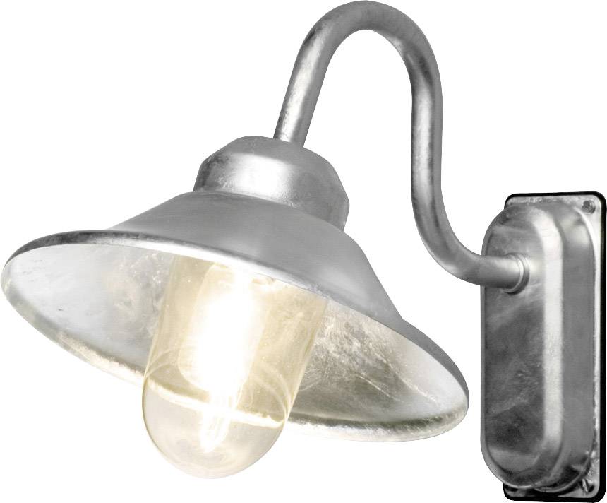 Srebrny kinkiet z zakrzywionym ramieniem i szklanym kloszem. Jest włączony i rozświetla pomieszczenie ciepłym światłem.