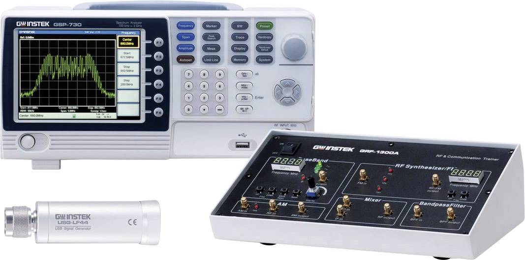 Urządzenie pomiarowe do analizy częstotliwości radiowych z ekranem wyświetlającym diagram spektralny. Obok znajduje się testowa skrzynka komunikacji radiowej.
