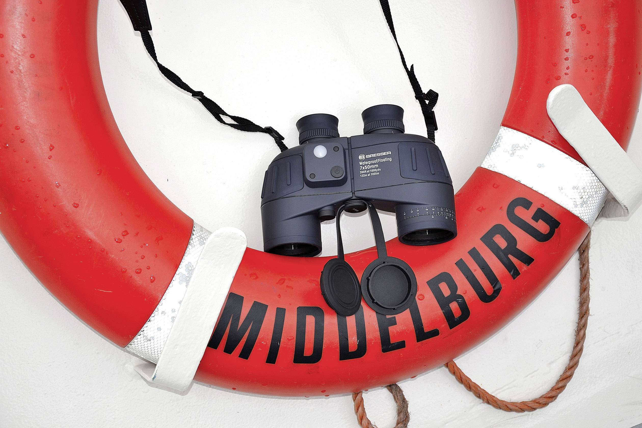 Czerwony koło ratunkowe z czarną lornetką na nim, napis 'Middelburg'.