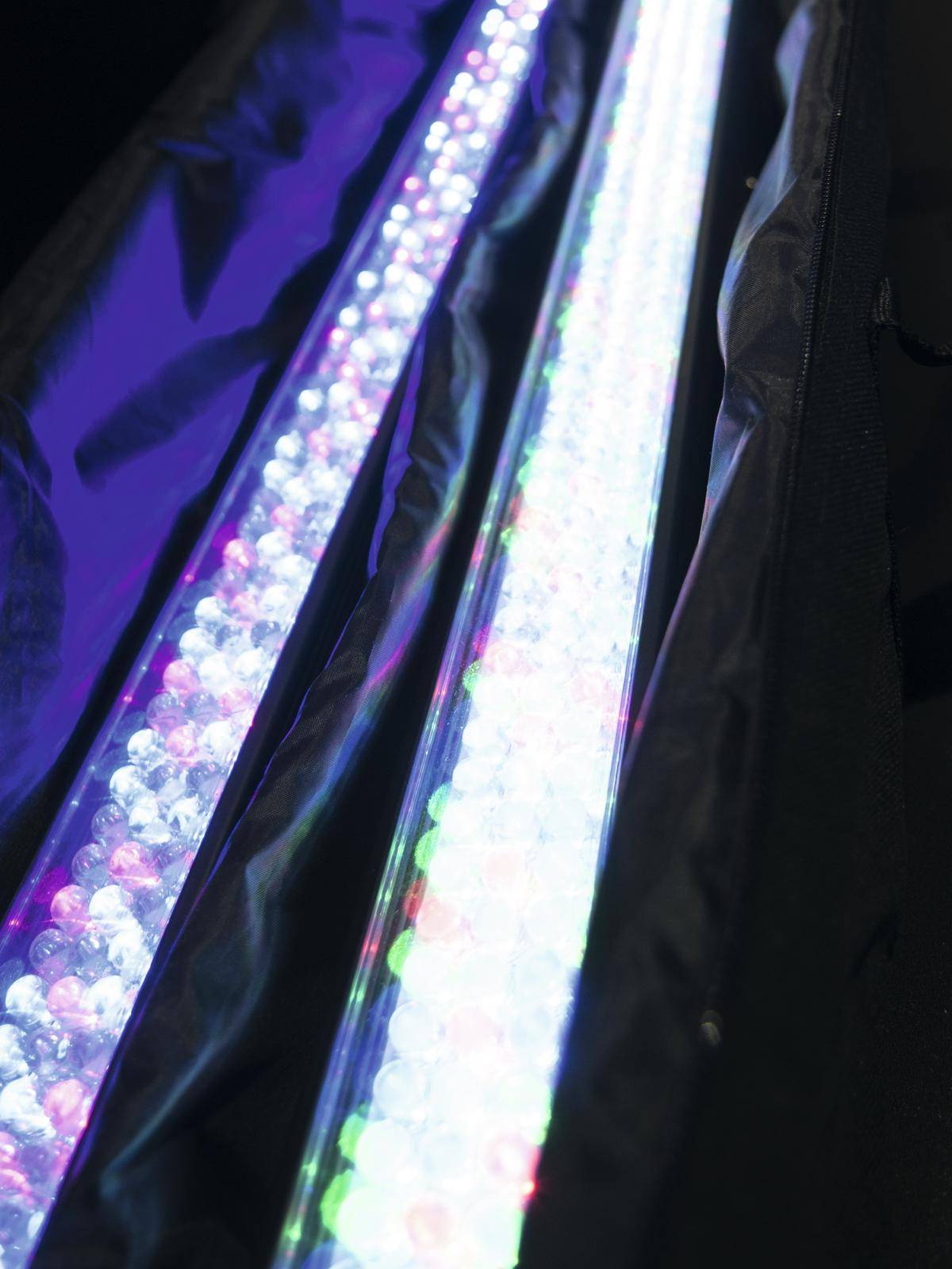 Długie świetlówki LED w ciemnym pomieszczeniu, z jasnymi, kolorowymi światłami tworzącymi futurystyczną atmosferę.