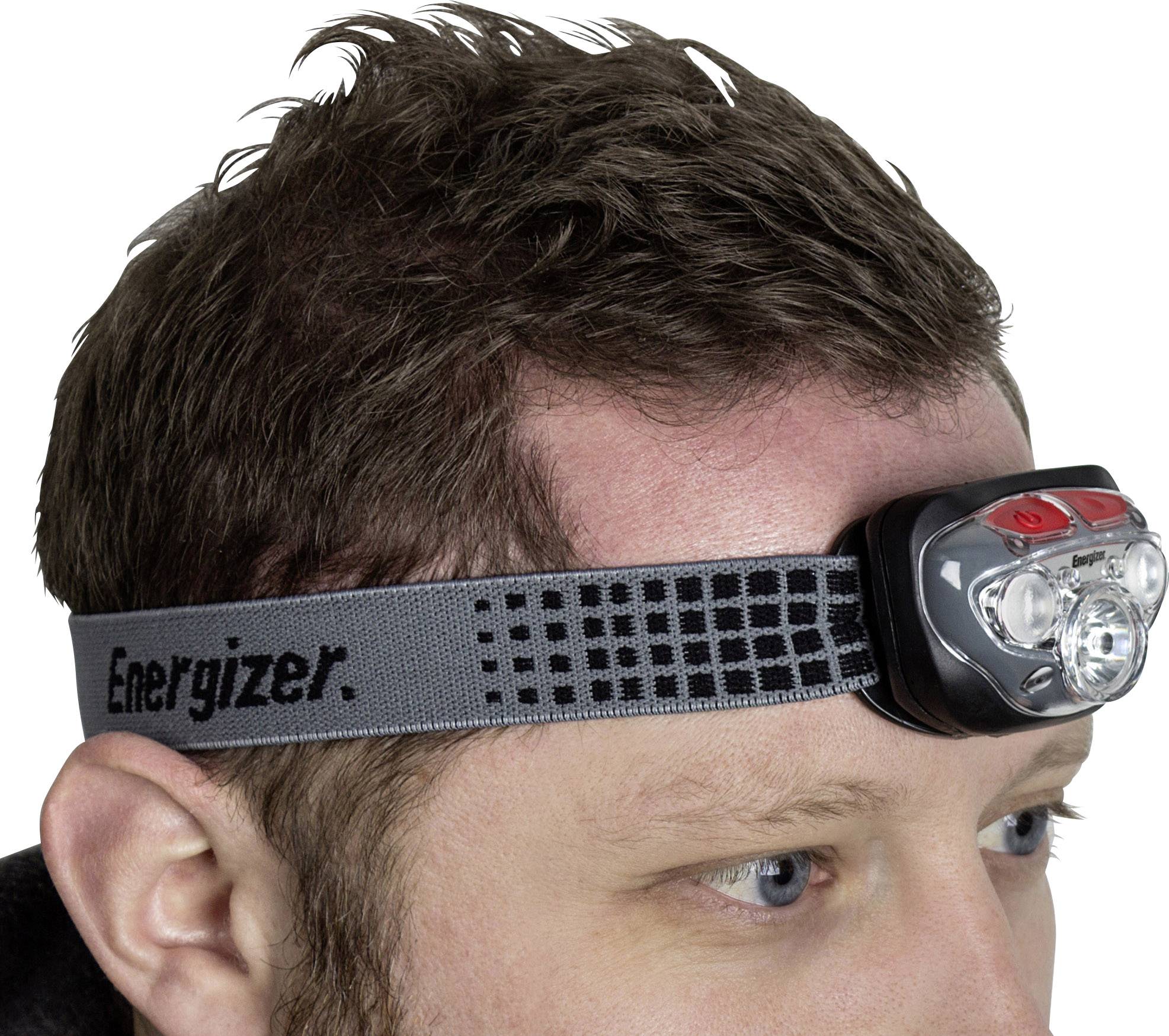 Osoba nosi czołówkę z szarym paskiem, na którym widnieje napis 'Energizer'. Lampka posiada kilka diod LED i jest przymocowana do głowy.
