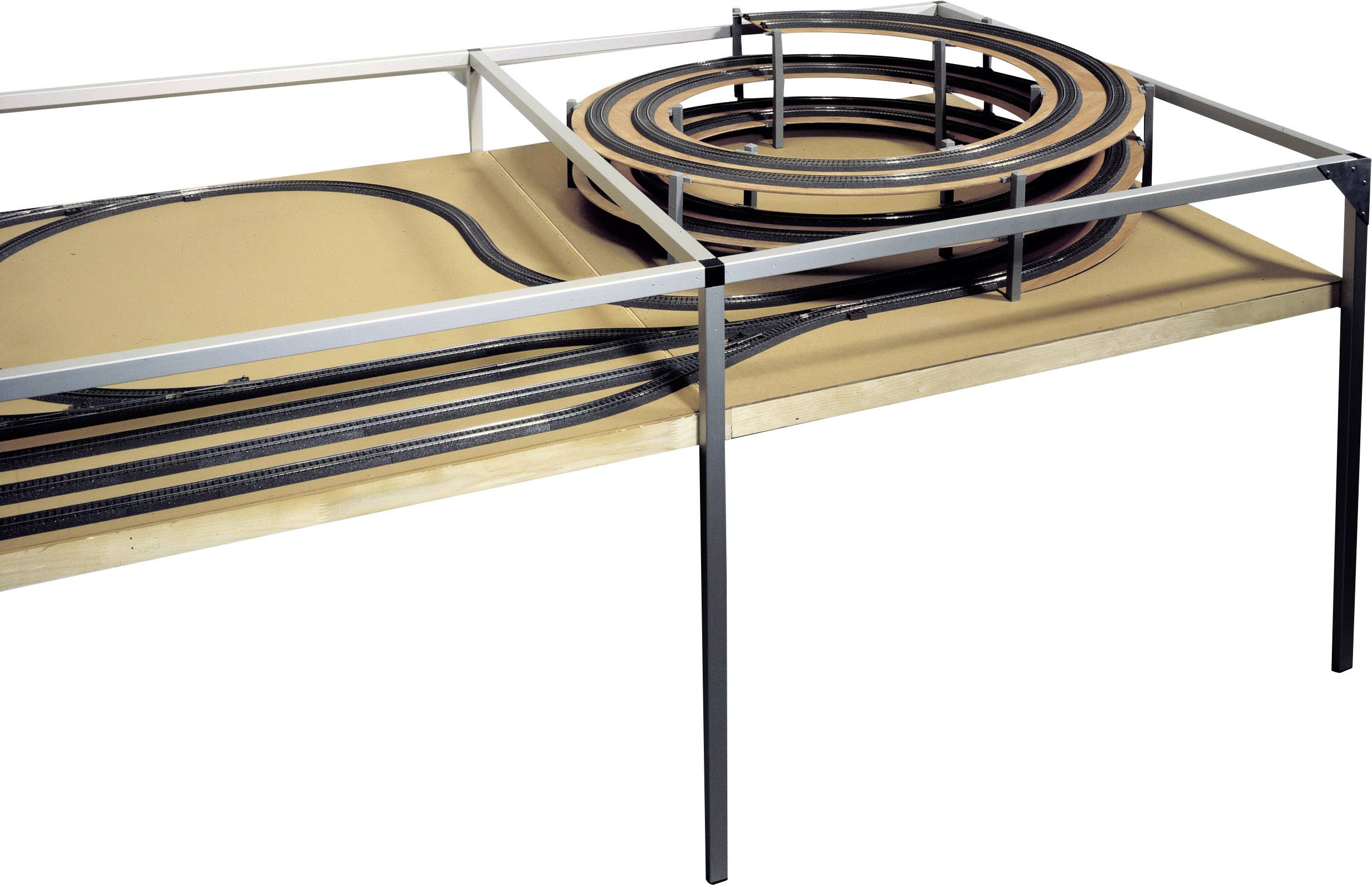Miniaturowa kolejka na stole z torami ułożonymi na podwyższeniu w formie spirali na wielu poziomach. Tory biegną wokół szkieletu konstrukcji.