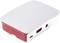 Biała i czerwona plastikowa obudowa mini-komputera z portami z przodu i wytłoczonym logo na pokrywie.