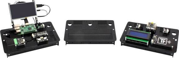 Trzy elektroniczne płytki prototypowe: Po lewej stronie z ekranem i płytką drukowaną, pośrodku pusta, po prawej stronie z wyświetlaczem cyfrowym i płytką drukowaną z logo 'TF'.