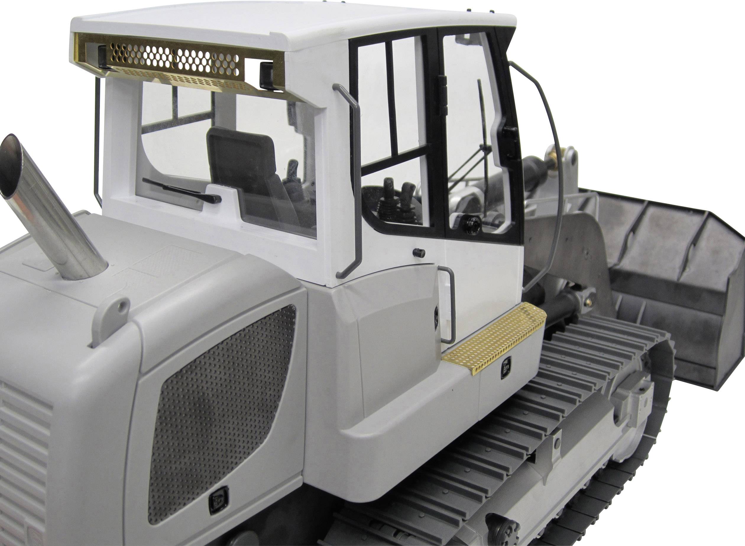 Biały, duży spychacz gąsienicowy, sfotografowany z boku, z widoczną kabiną operatora i łyżką z przodu.