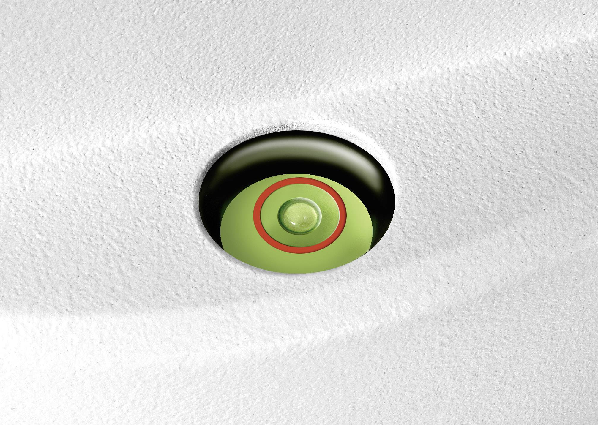 Zbliżenie zielonego przycisku otoczonego czerwonym pierścieniem, osadzonego na gładkiej białej powierzchni.