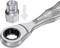 Srebrny łeb grzechotki z nasadką klucza nasadowego. Strzałka wskazuje połączenie obu części.