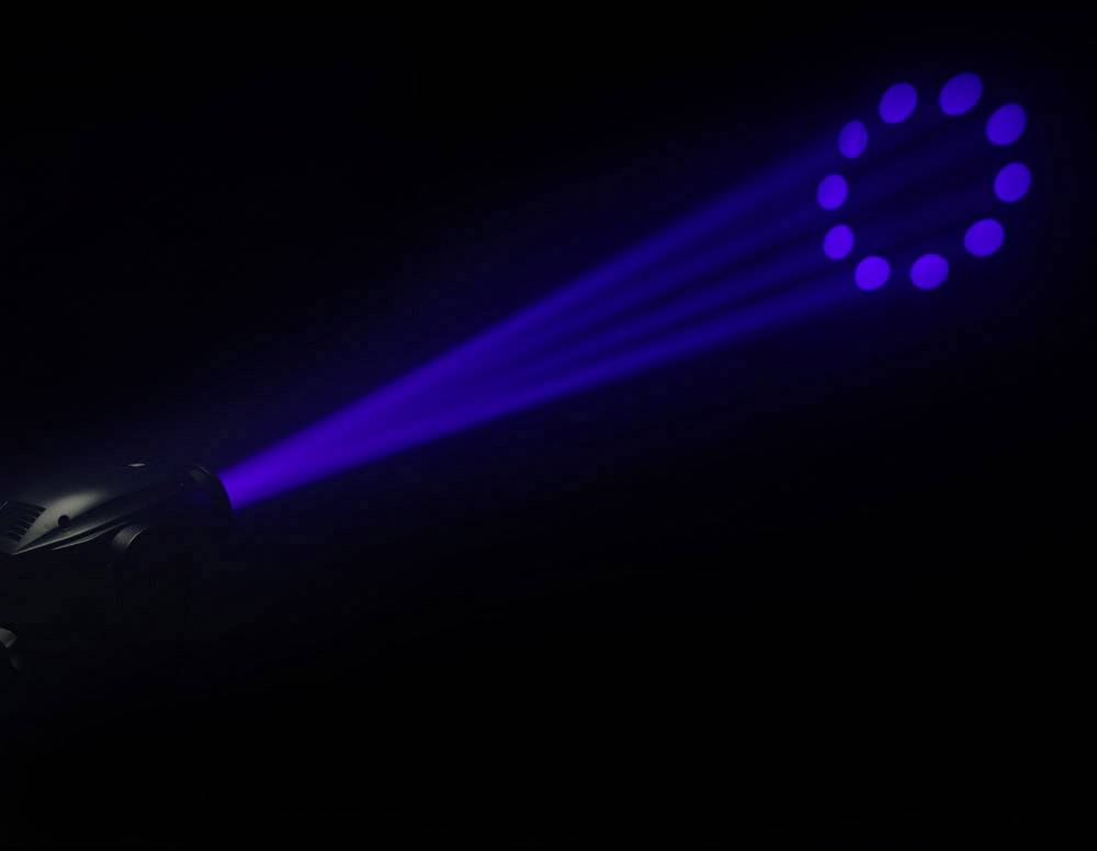 Reflektor rzucający niebieskie światło projektuje koło z punktów na ciemną powierzchnię.