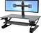 Regulowany pionowo dodatkowy blat biurkowy z zamontowanymi dwoma monitorami, idealny do ergonomicznego urządzenia stanowiska pracy.