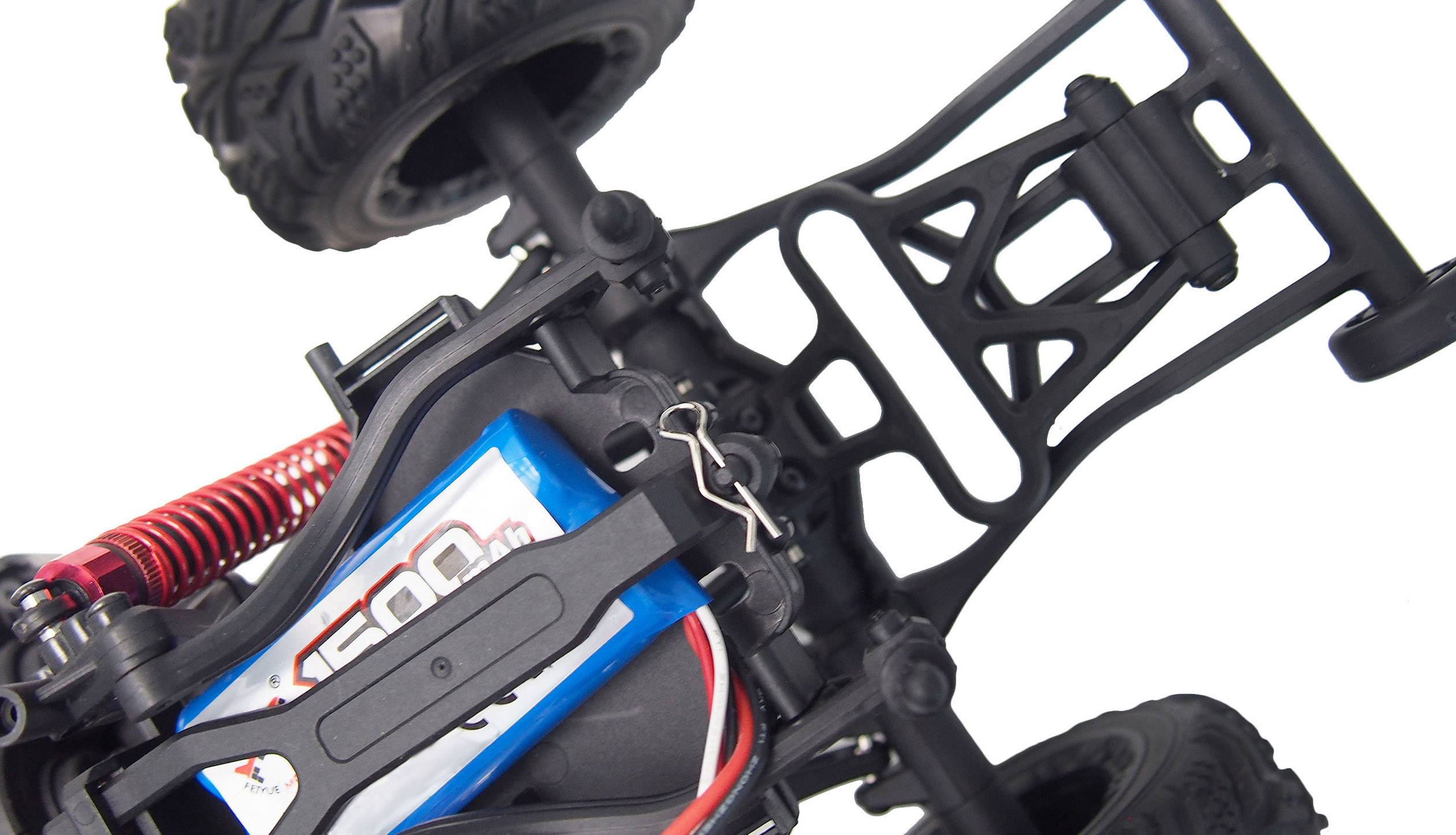 Zbliżenie zdalnie sterowanego samochodu, ukazujące podwozie, osie i sprężyny. Widoczny jest wbudowany akumulator o pojemności 1500 mAh.