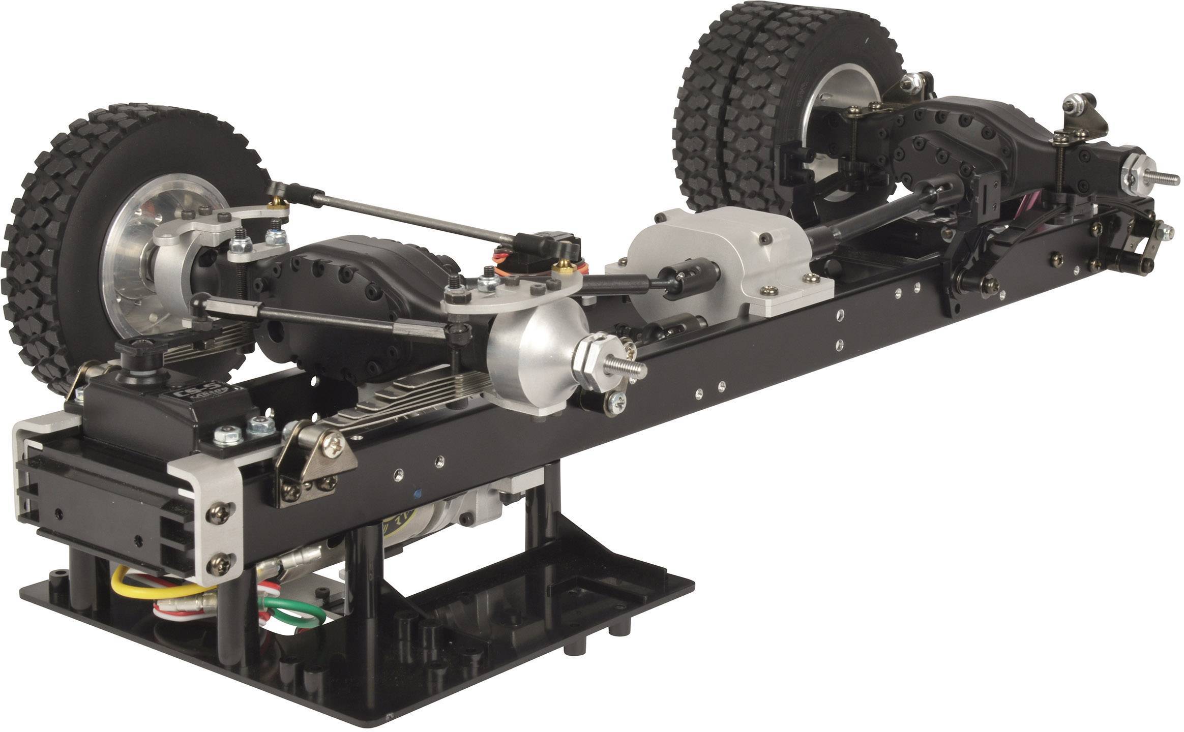 Zdalnie sterowane podwozie samochodu, widoczne są koła, wał napędowy i amortyzatory. Model jest niekompletny i niemontowany.