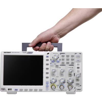 Jedna ręka trzyma przenośny oscyloskop, model Voltcraft DSO-6102 WIFI, z wyświetlaczem i kilkoma pokrętłami do obsługi.