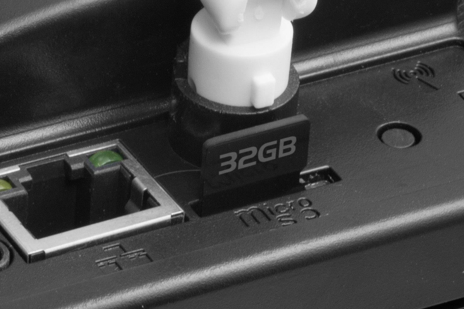 Zbliżenie 32-gigabajtowej karty Micro SD włożonej do gniazda obok złącza Ethernet w urządzeniu elektronicznym.