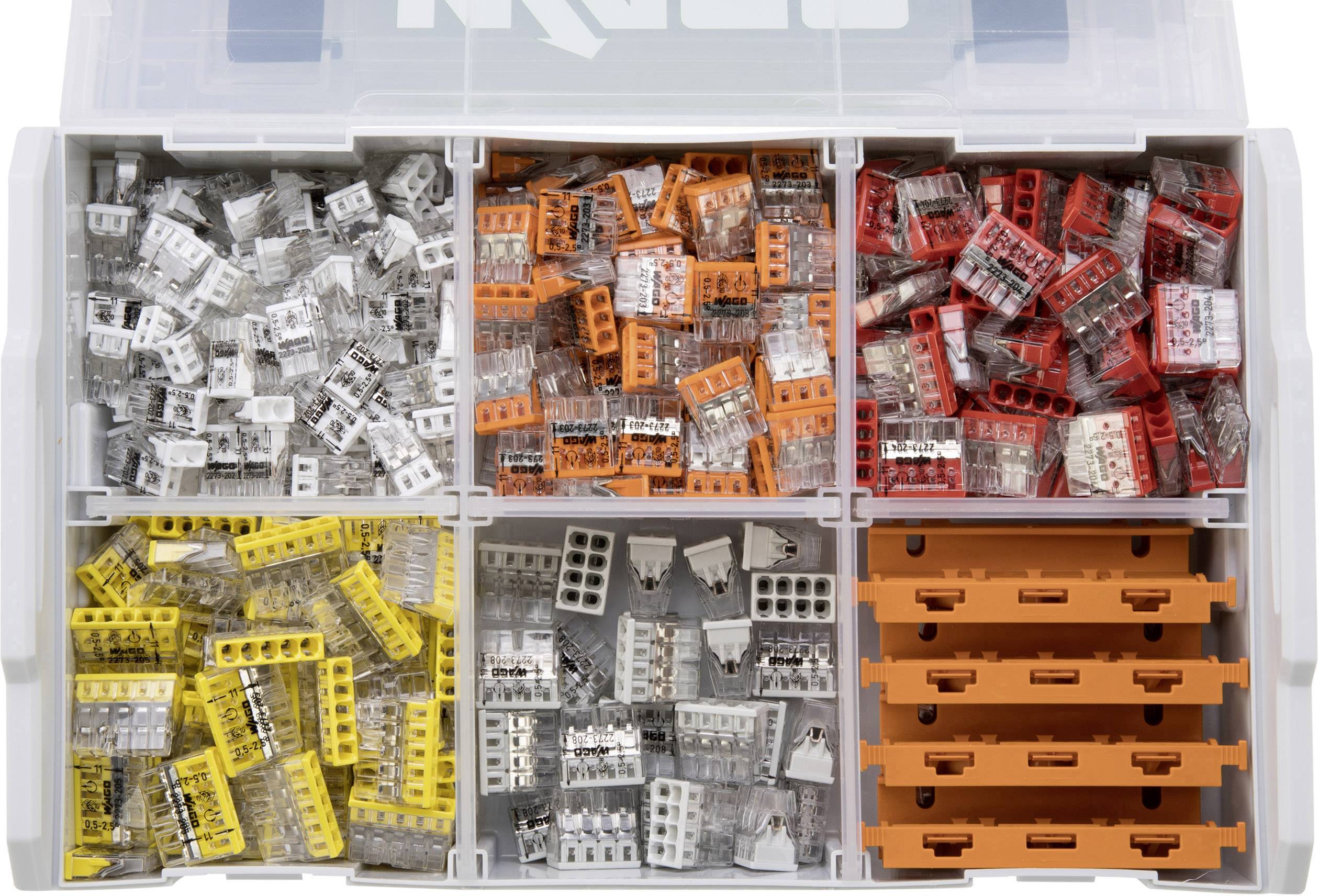 Zestaw złączek elektrycznych w różnych kolorach, ułożonych w sześciu przegródkach: białe, pomarańczowe, czerwone, żółte, szare oraz puste pomarańczowe.