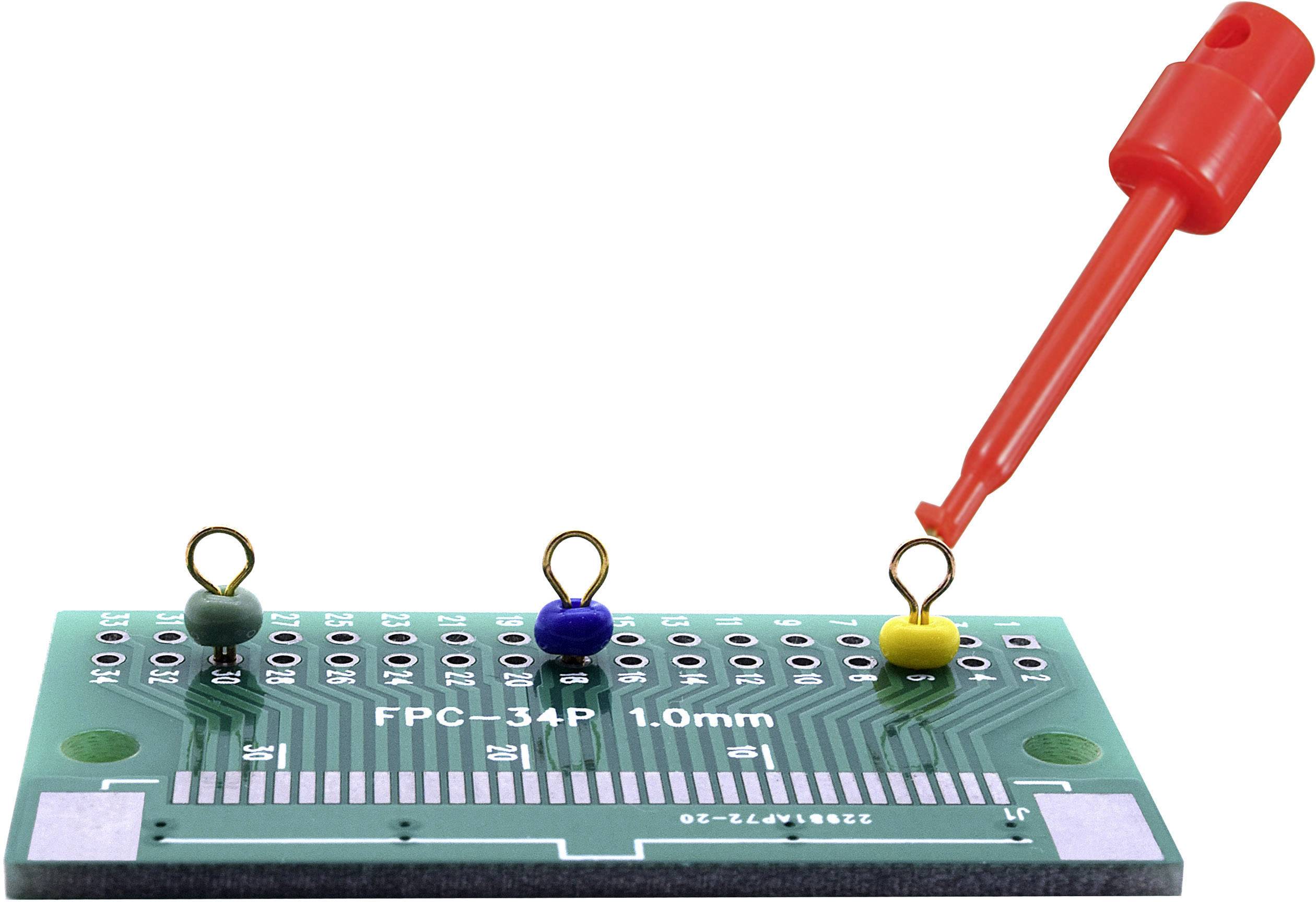 Zielona płytka drukowana z adapterem, posiadająca wiele styków, na których zamocowane są zaciski w różnych kolorach, z czerwoną sondą pomiarową dotykającą żółtego zacisku.