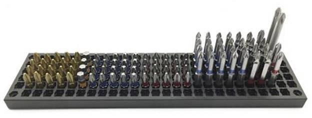 Zestaw różnych końcówek wkrętakowych w czarnym plastikowym uchwycie, ułożonych według rozmiaru i kształtu.