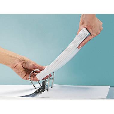 Osoba dziurkuje stos papieru dziurkaczem na niebieskim tle.