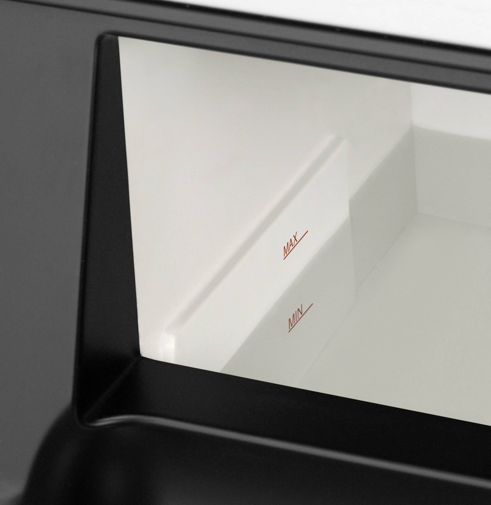 Zbliżenie białego pojemnika z czarnymi krawędziami. We wnętrzu widoczne są czerwone oznaczenia 'MIN' i 'MAX'.