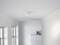 Minimalistycznie urządzone pomieszczenie z białymi ścianami i sufitem. Na suficie zamontowany jest pojedynczy reflektor.