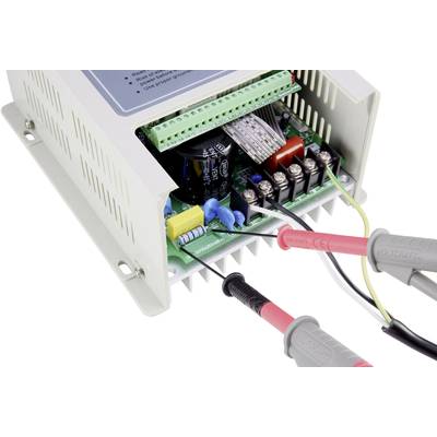 Otwarty elektroniczny sprzęt prezentuje kilka połączeń kablowych i elementów na płytce drukowanej. Dwa przewody pomiarowe są podłączone.