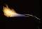 Palnik wyrzuca gorący płomień, który przechodzi od niebieskiego przy końcu palnika do pomarańczowego na jego czubku.
