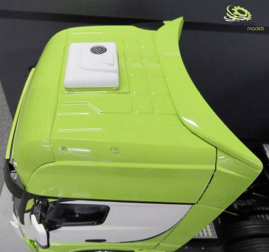 Zielony samochód ciężarowy widziany z góry, pokazujący kabinę i spoiler, na czarnym tle.