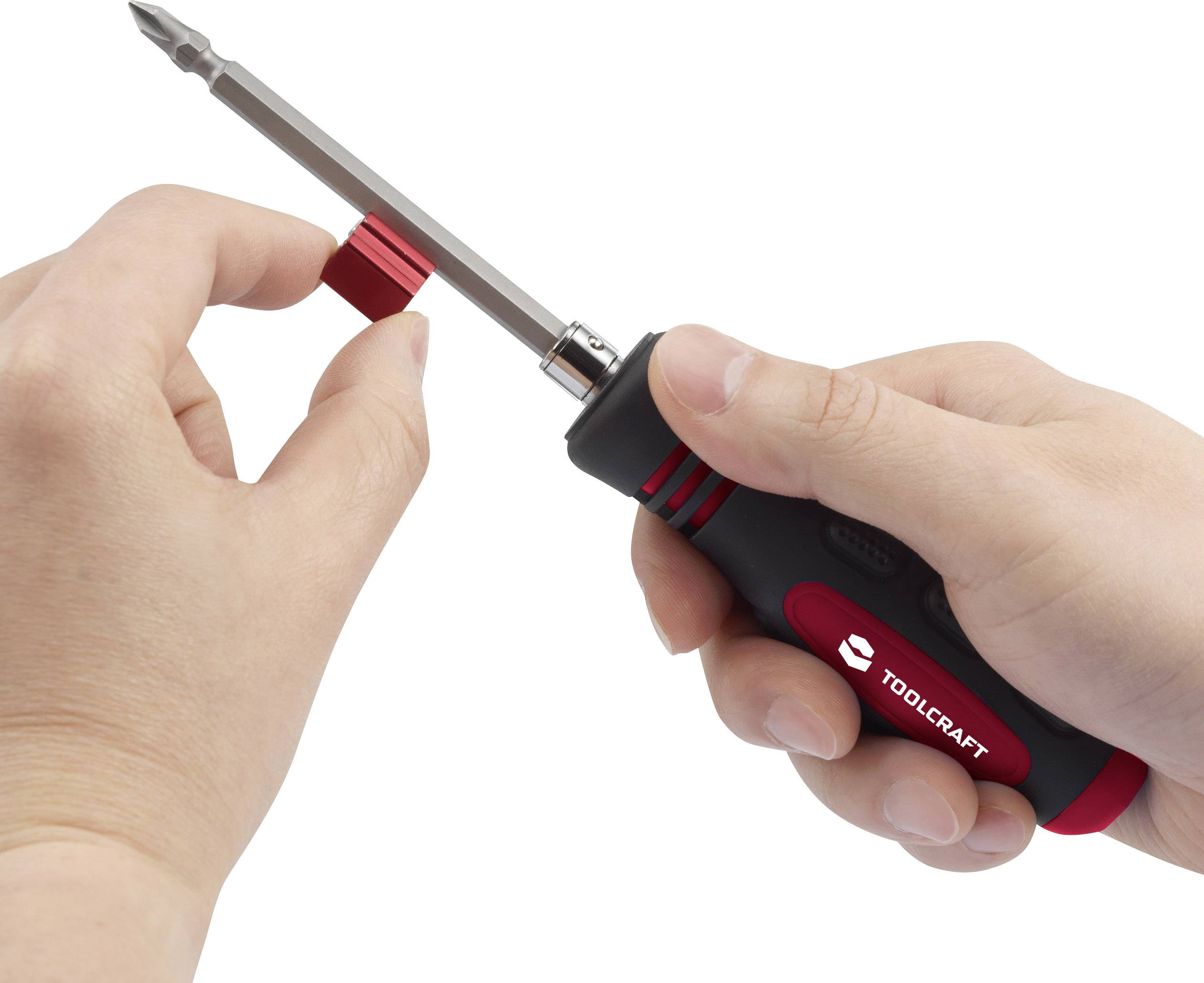 Jedna ręka trzyma wkrętak TOOLCRAFT, druga nakłada czerwono-czarny kapturek na wkrętak.