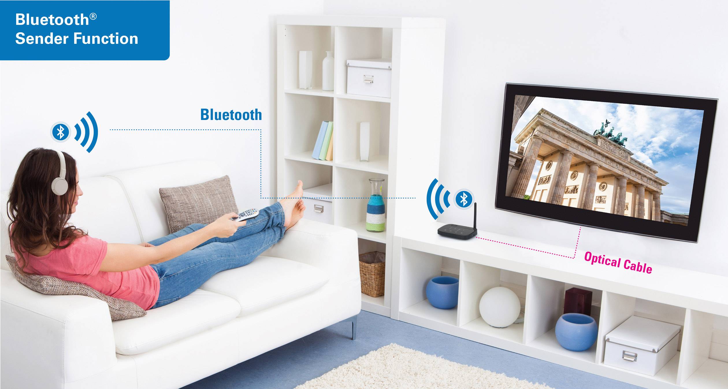 Osoba siedzi na kanapie i słucha muzyki przez słuchawki Bluetooth podłączone do telewizora. Dodatkowo podłączony jest również kabel optyczny.