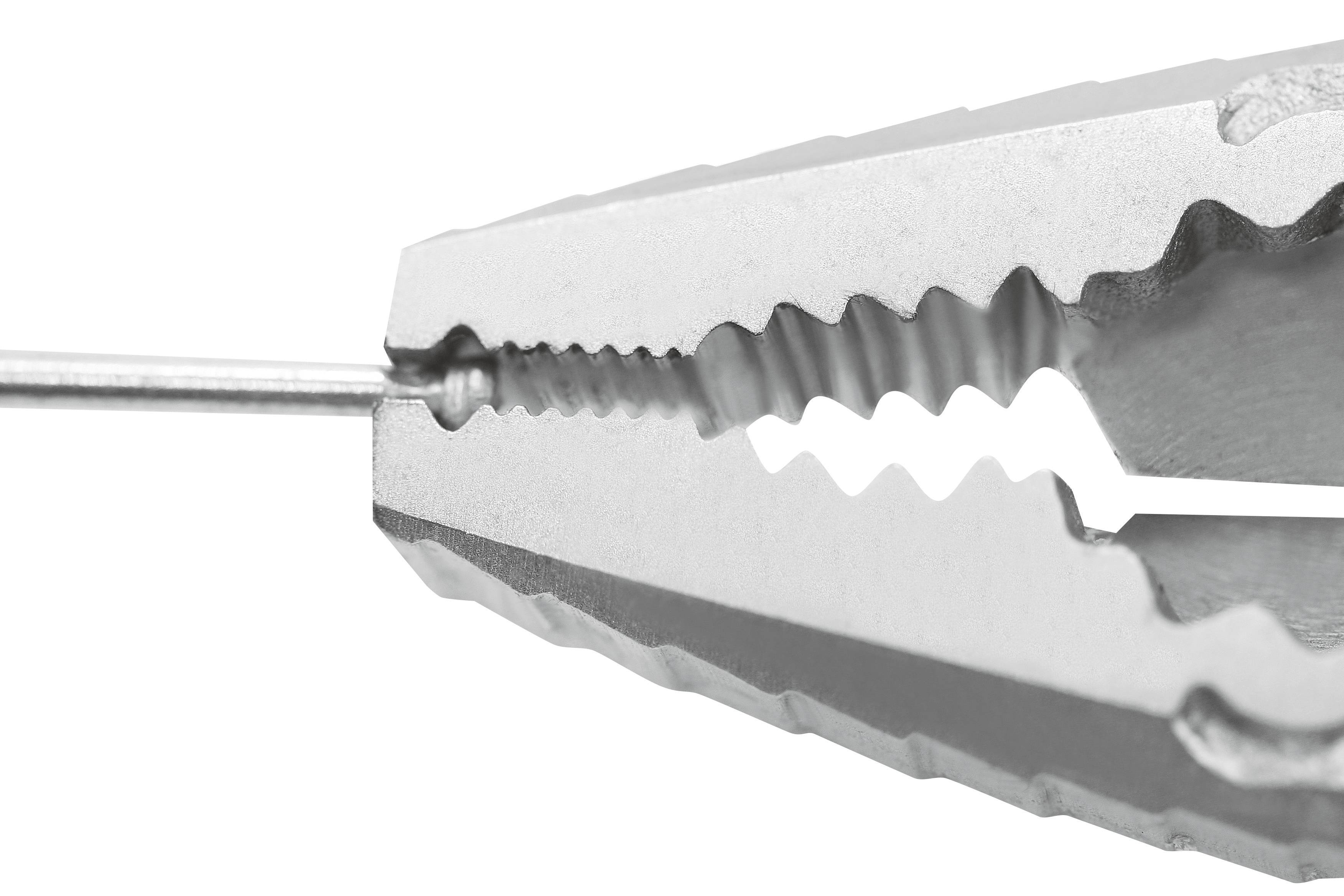 Zbliżenie srebrnego, ząbkowanego uchwytu trzymającego cienki kawałek metalu. Powierzchnia jest strukturalna i odbija światło.
