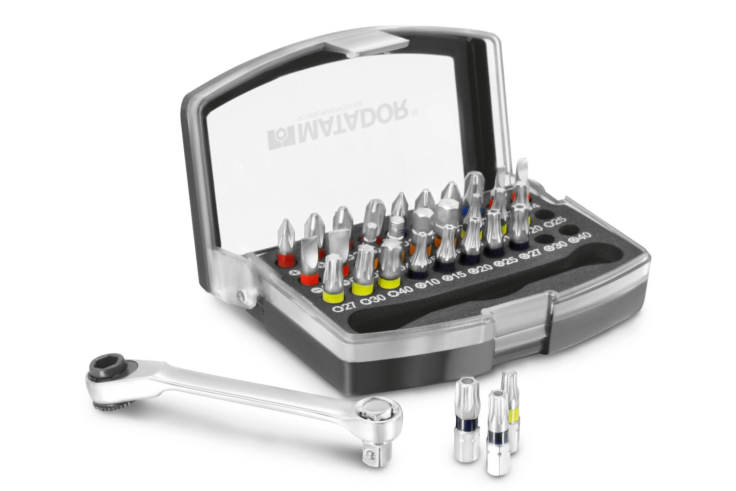 Zestaw bitów z różnymi końcówkami wkrętakowymi w otwartym pudełku. Obok leży klucz grzechotkowy.