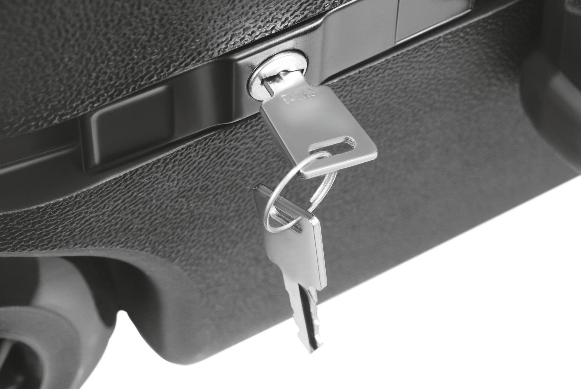 Czarno-biała walizka z kluczem włożonym w zamek, ukazująca mechanizm blokujący i funkcję zabezpieczającą bagażu.