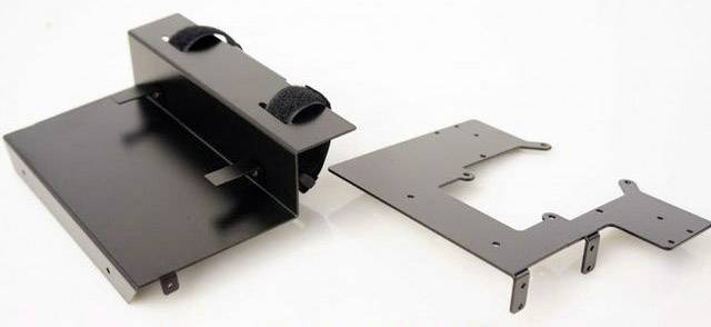 Czarny zestaw mocujący z metalu składający się z dwóch elementów. Jeden element posiada prostokątne uchwyty i rzepy, drugi jest płaski i prostokątny.
