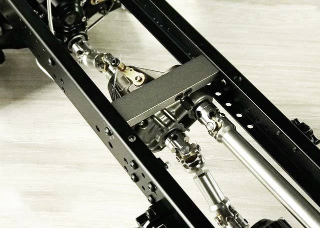 Zbliżenie podwozia z widocznymi wałami napędowymi i elementami osi, podkreślające strukturę mechaniczną.