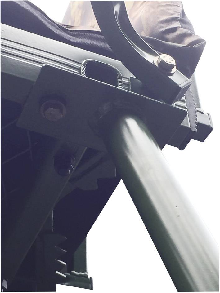 Osoba siedzi na platformie obserwacyjnej, sfotografowana z perspektywy żabiej. Nacisk położony jest na metalowej strukturze platformy.