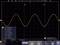 Wyświetlacz oscyloskopu: Żółta fala sinusoidalna o częstotliwości 902,5 Hz, amplitudzie 7,8V, okresie około 1,108 ms. Widoczne współrzędne i pomiar czasu.