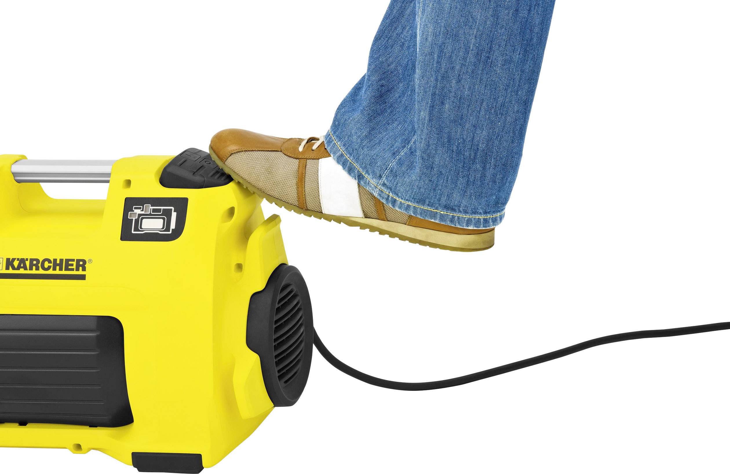 Stopa naciska na żółtą myjkę ciśnieniową, aby ją włączyć. Czarny kabel biegnie od urządzenia.