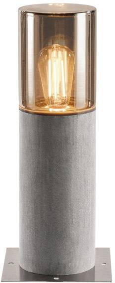 Lampa stojąca z przezroczystym szkłem i widoczną żarówką, zamontowana na cylindrycznym postumencie.