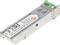 Metalowy moduł transceivera SFP z zieloną zakładką, stosowany w podłączeniach sieciowych w urządzeniach komunikacyjnych pracujących w technologii światłowodowej.