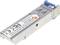 Moduł SFP do sieci, oznaczony znakiem CE i informacjami producenta. Posiada metalową obudowę z niebieską zakładką na jednym końcu.