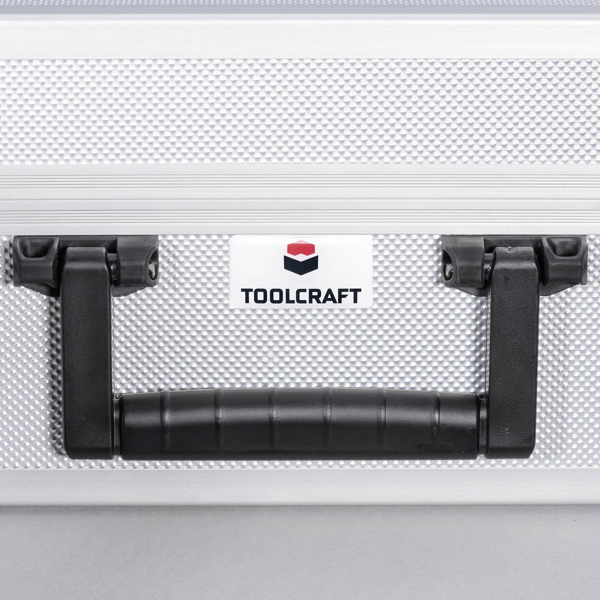 Srebrna skrzynka narzędziowa z czarną rączką i logo 'Toolcraft' na przedniej stronie.