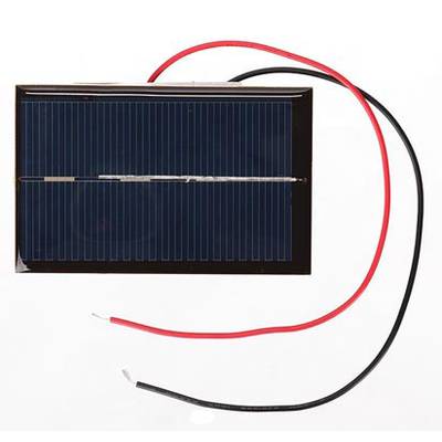 Mały panel słoneczny z czerwonymi i czarnymi przewodami, odpowiedni do prostych projektów elektrycznych lub demonstracji energii słonecznej.