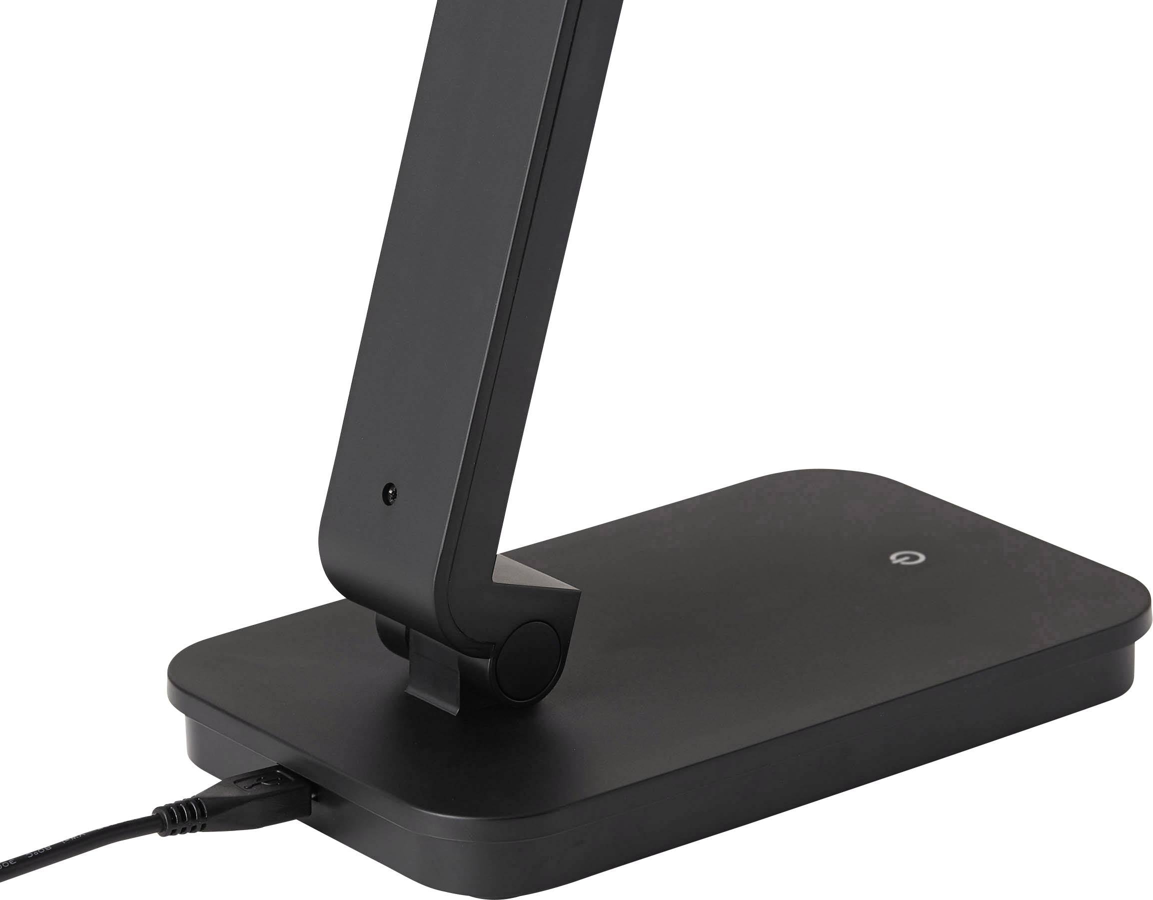 Nowoczesna, czarna lampa stołowa o smukłej sylwetce. Lampa jest włączona, co widać po podłączonym przewodzie.